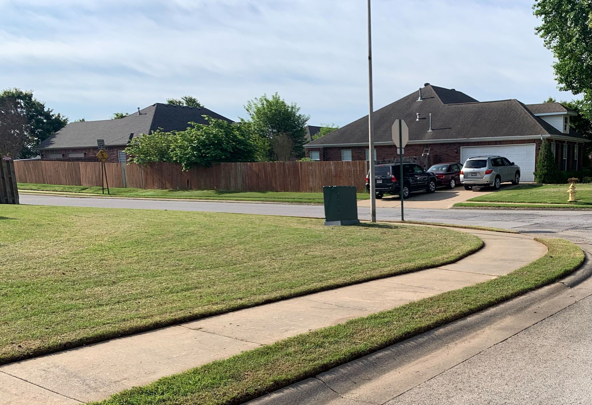 A residential street with cars parked on the side of it