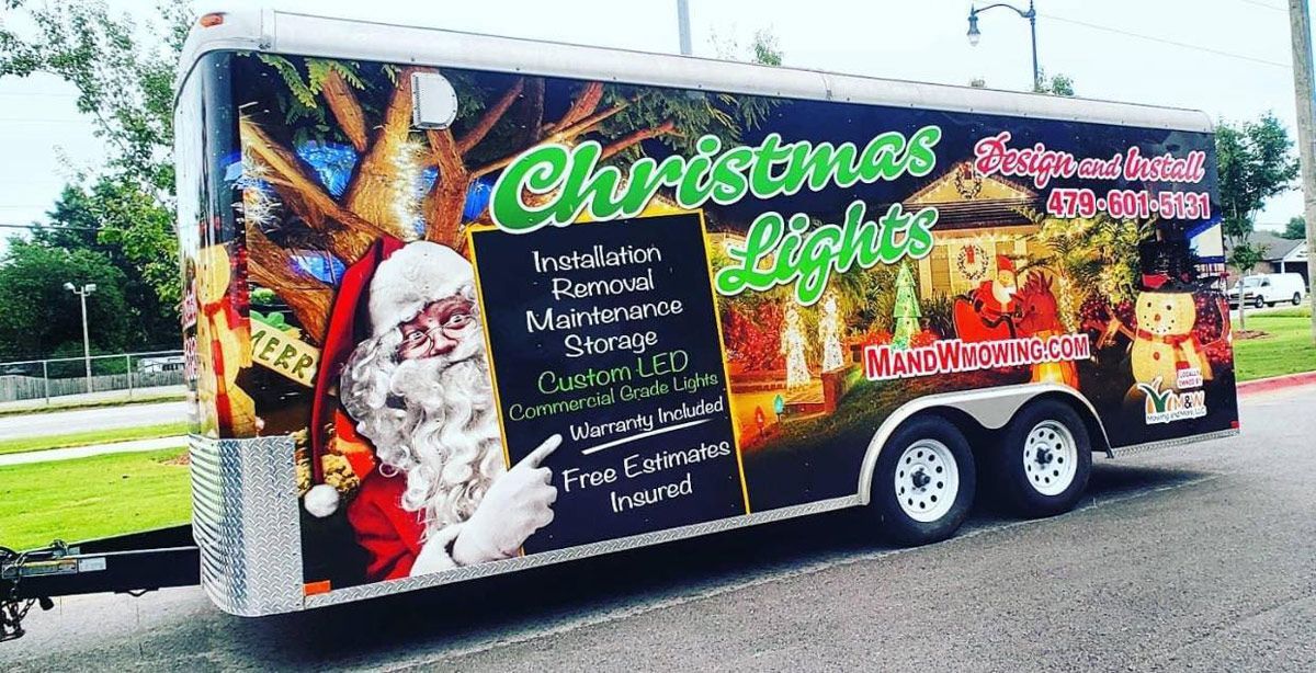 A trailer with a picture of santa claus on it is parked on the side of the road.