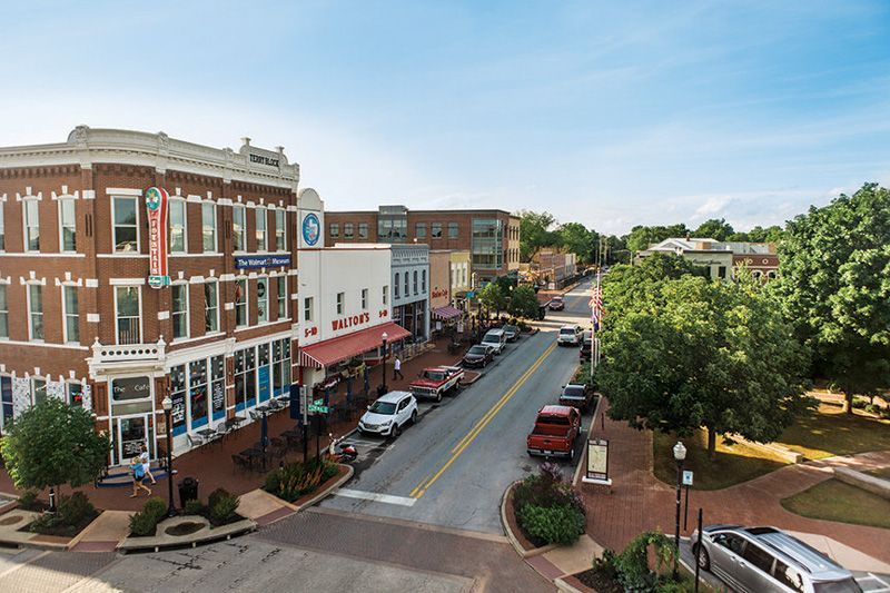 An aerial view of a small town with cars parked on the side of the road.