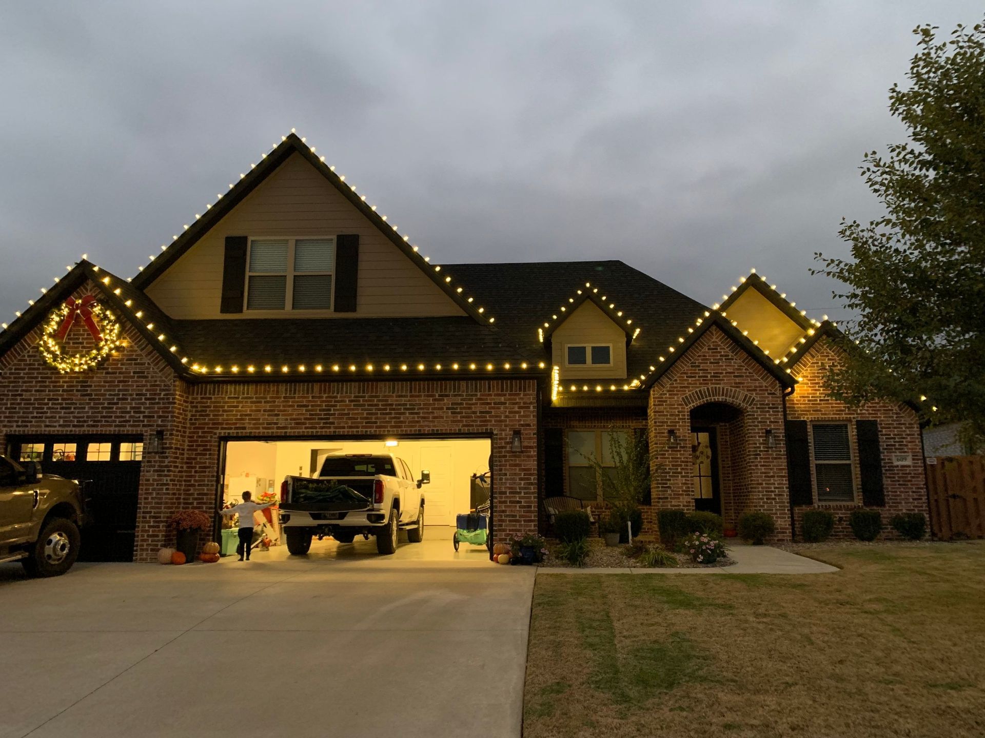 A brick house with christmas lights on the roof