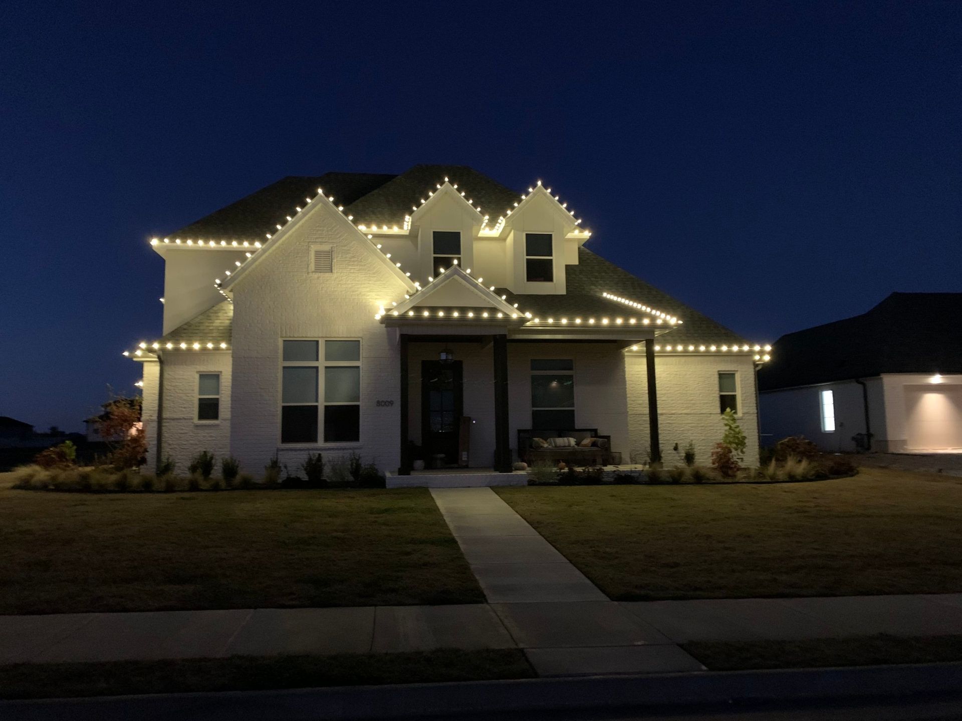 A house is lit up with christmas lights at night