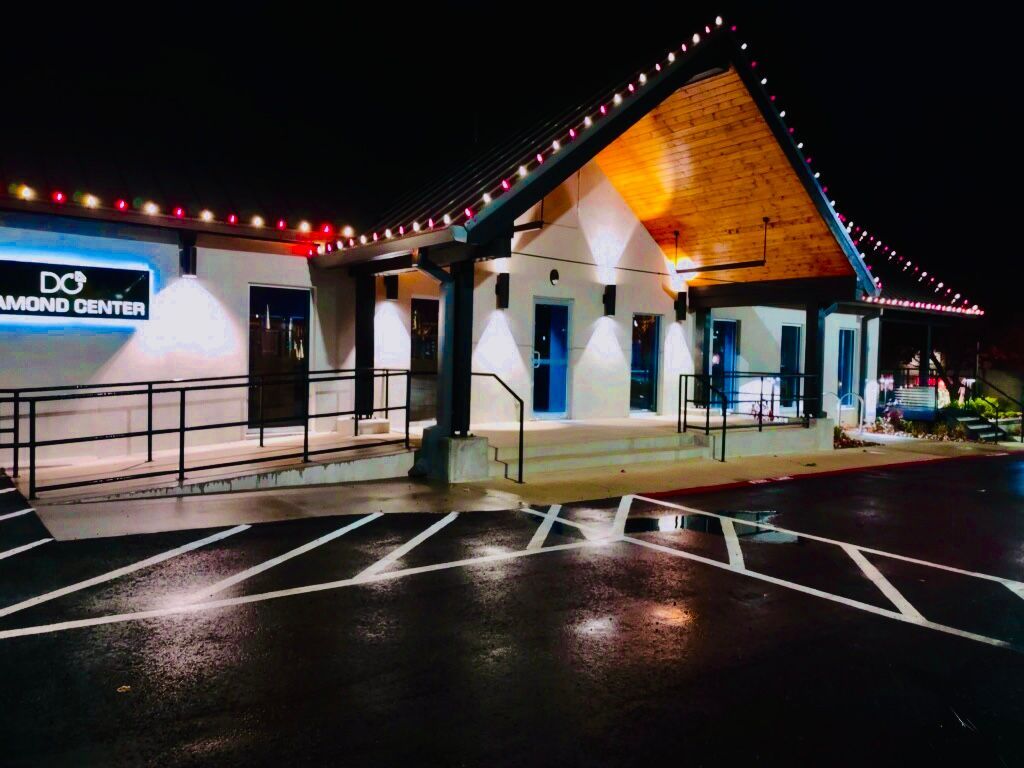 A diamond center building is lit up at night