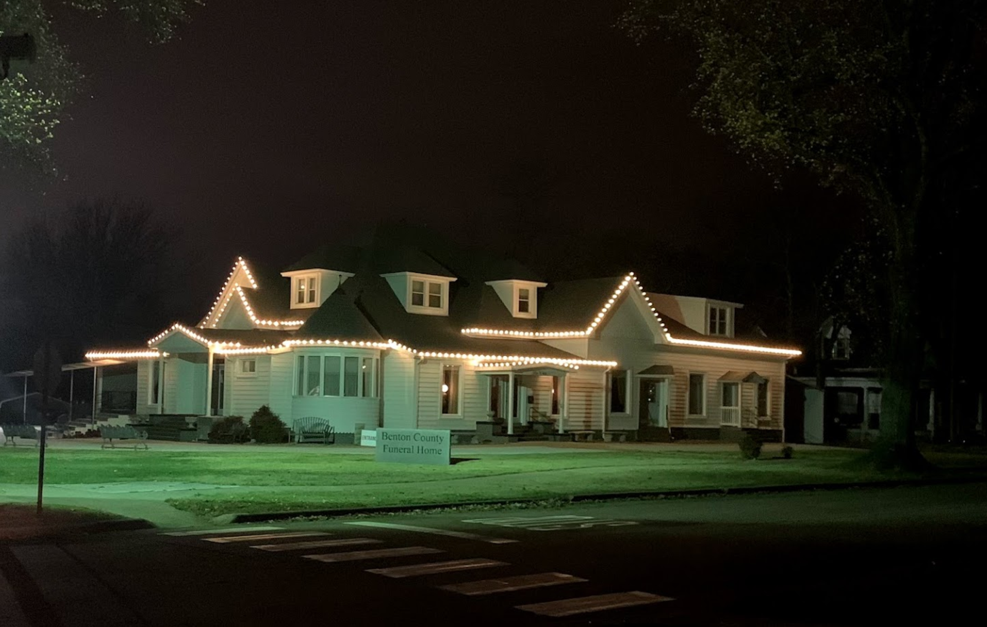 A house is lit up with christmas lights at night