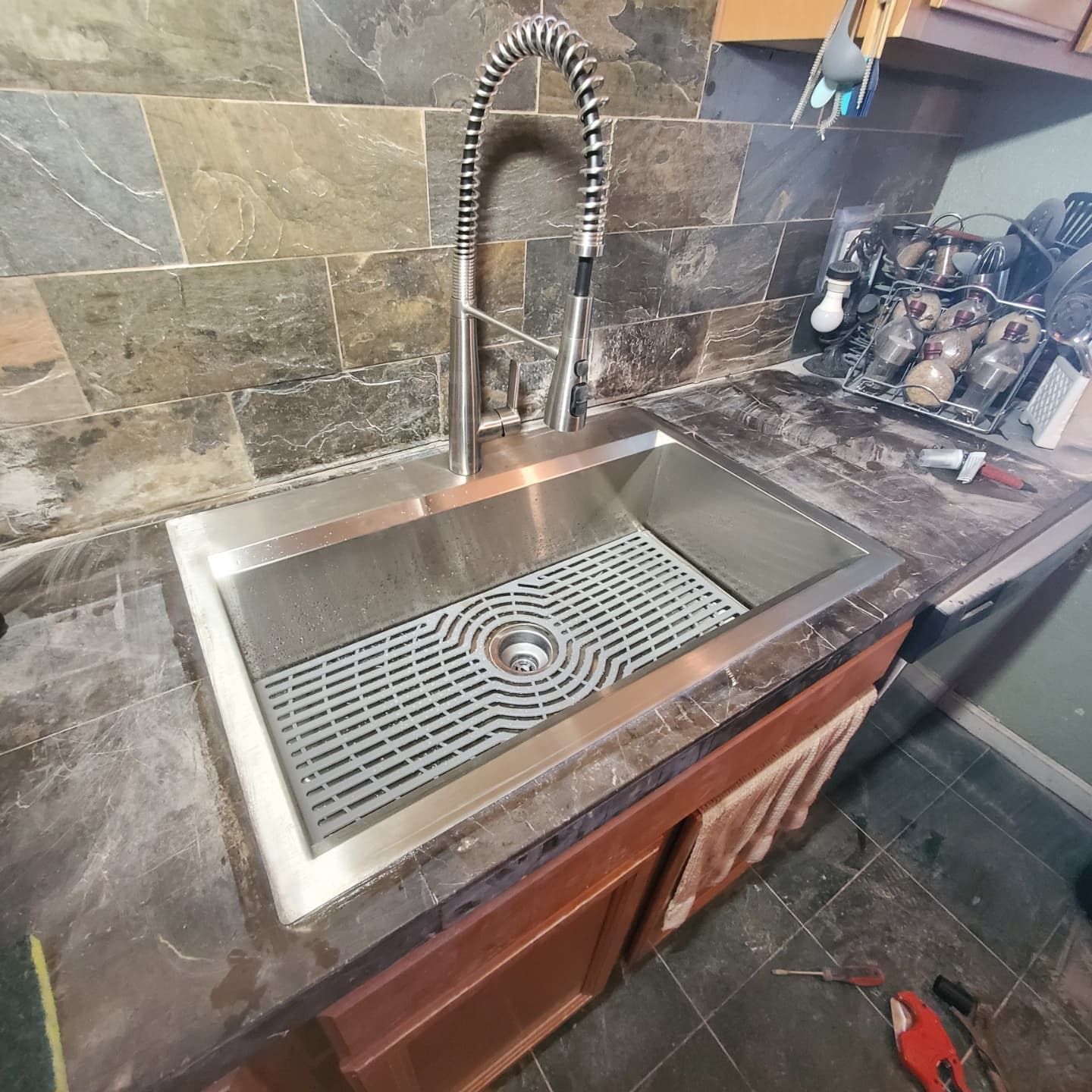 A stainless steel kitchen sink with a faucet