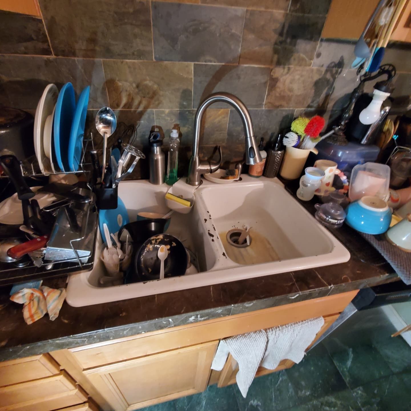 A kitchen sink filled with dirty dishes and utensils