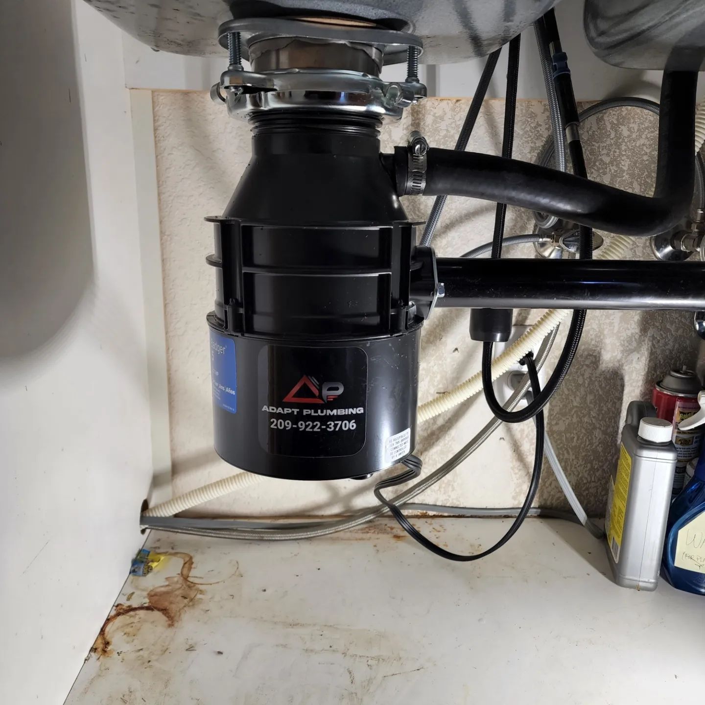 A black ap garbage disposal is under a sink