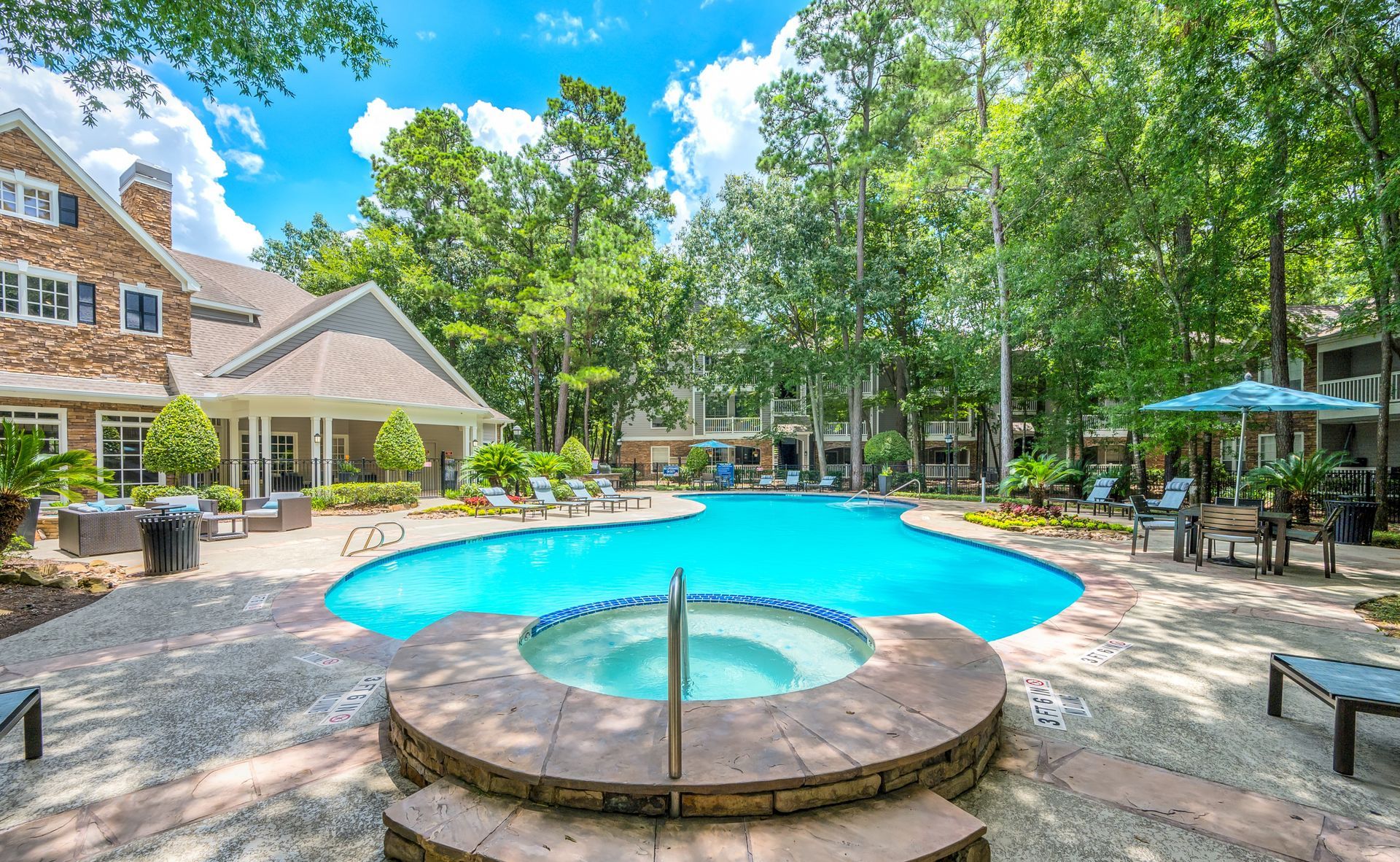 There is a large swimming pool with a hot tub in the middle of it.