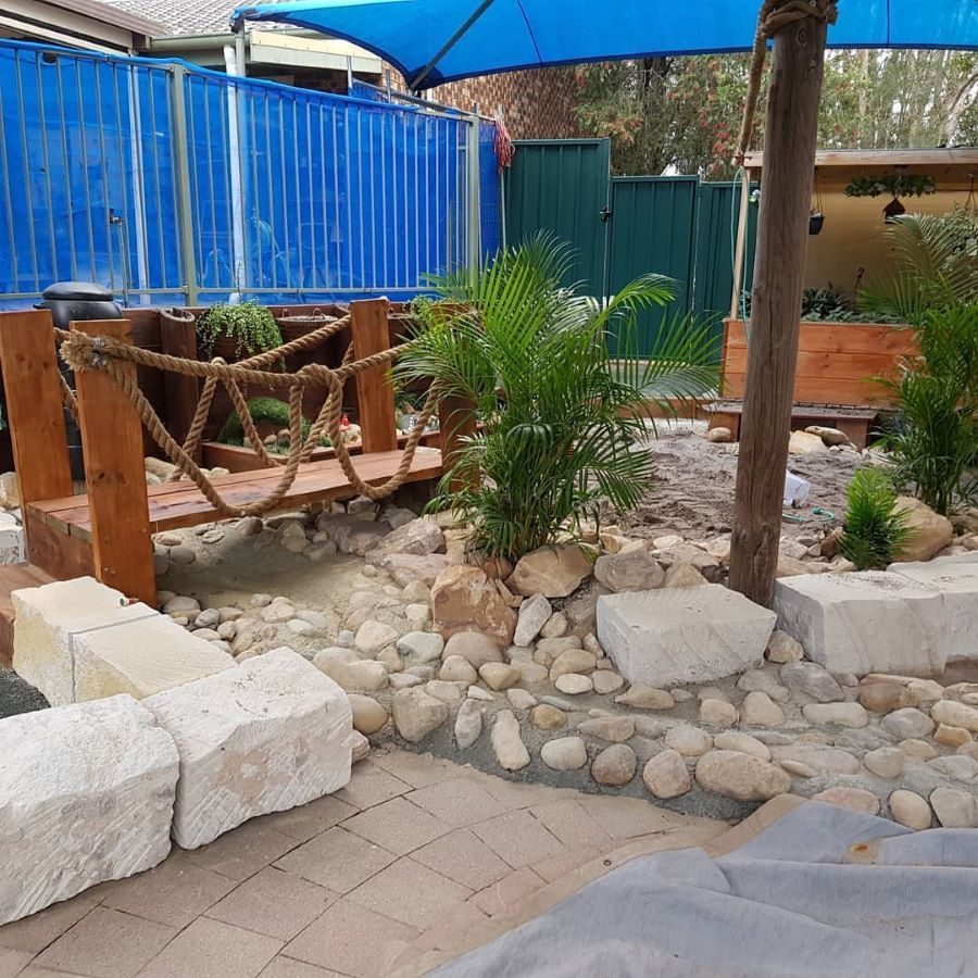 A Garden With a Wooden Bench and a Rope Bridge — Garden Vogue in Charlestown, NSW