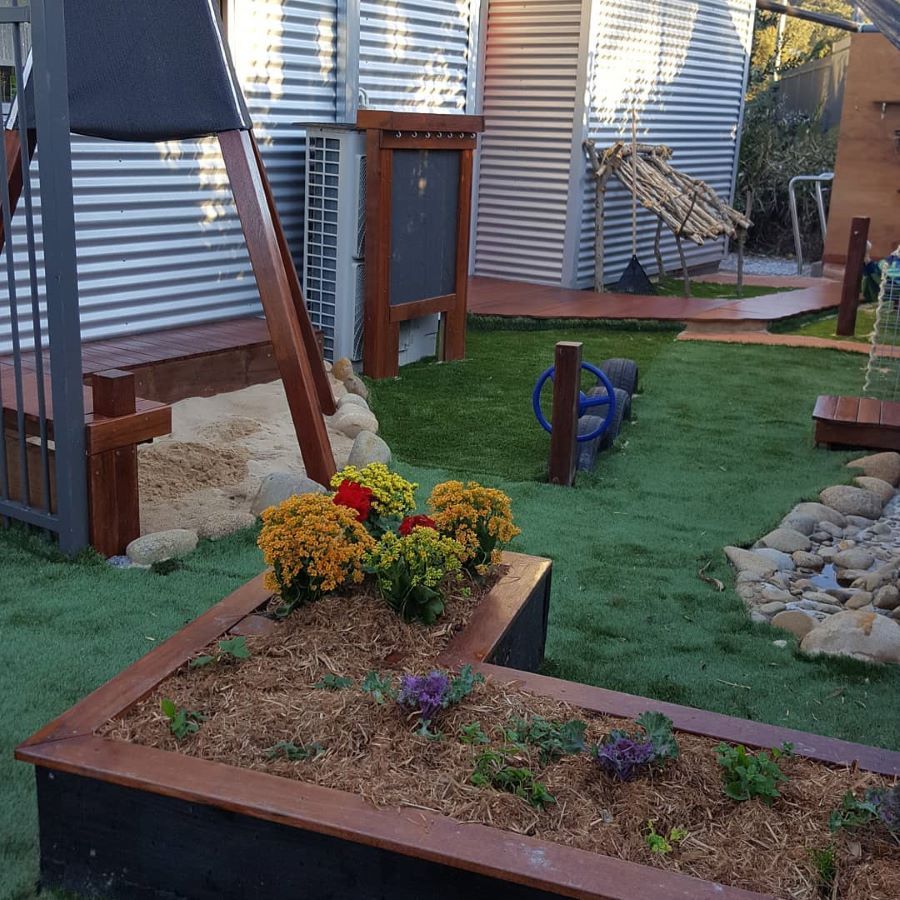 A Garden With Flowers and Rocks in Front of a House — Garden Vogue in Charlestown, NSW