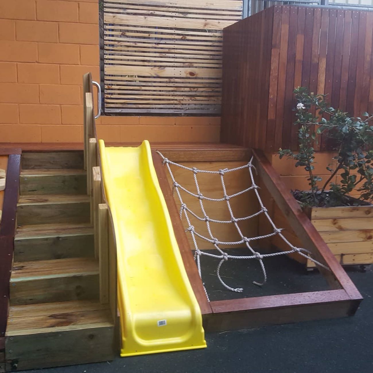 A Yellow Slide With a Rope Net Attached to It — Garden Vogue in Charlestown, NSW