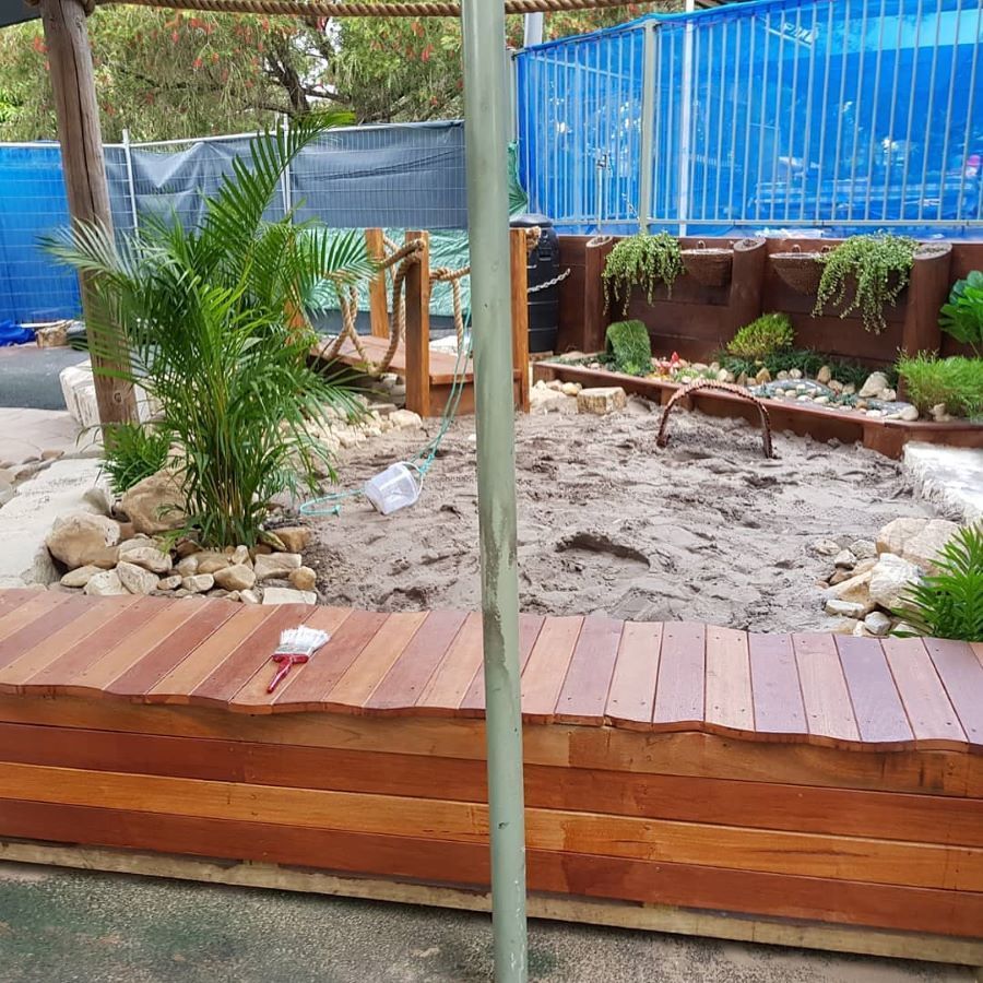 A Wooden Bench is Sitting in the Middle of a Sandy Area — Garden Vogue in Lake Macquarie, NSW