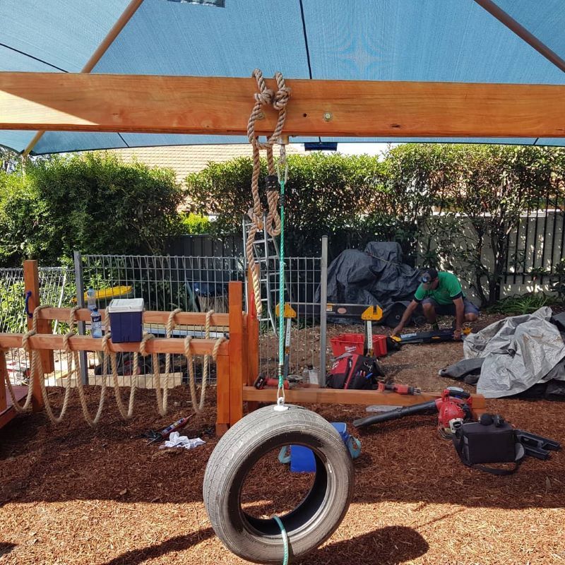 A Tire Swing is Hanging From a Wooden Structure — Garden Vogue in Charlestown, NSW