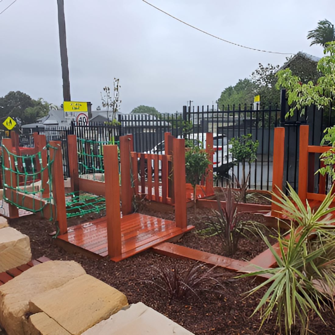 A Wooden Playground With a Fence and a Sign — Garden Vogue in Charlestown, NSW