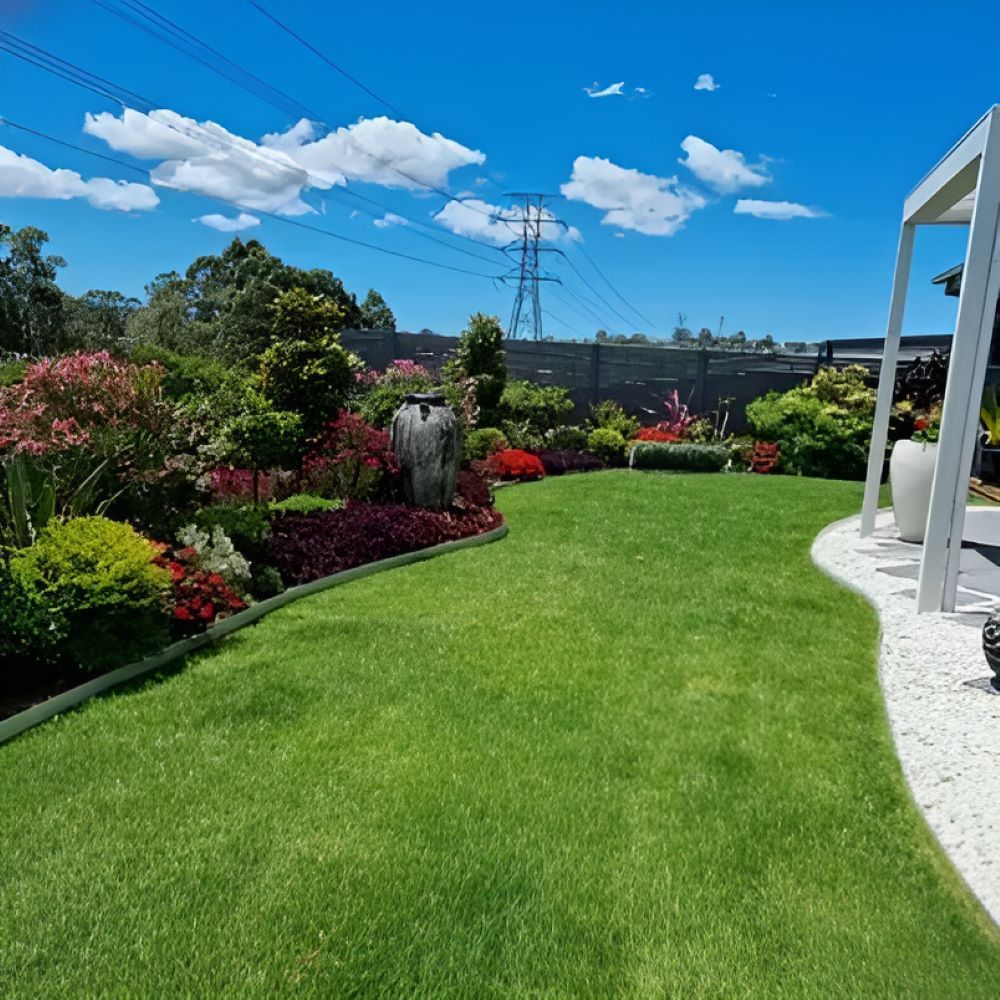 A Lush Green Lawn Surrounded by Flowers and Trees on a Sunny Day — Garden Vogue in Charlestown, NSW