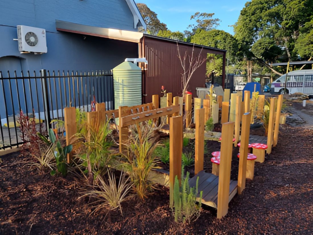 A Wooden Bridge is Surrounded by a Fence and a Water Tank — Garden Vogue in Charlestown, NSW