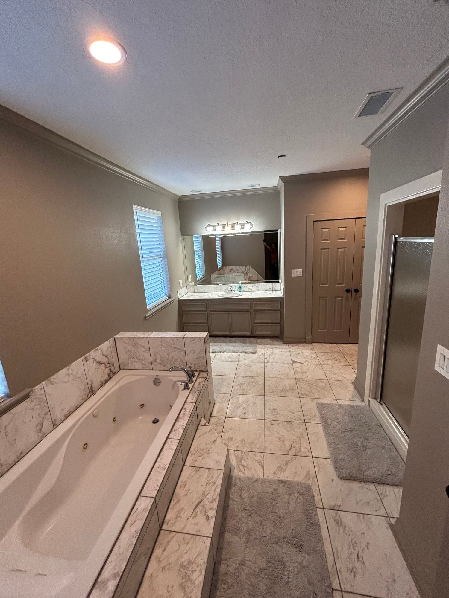 A bathroom with a jacuzzi tub and a large mirror.