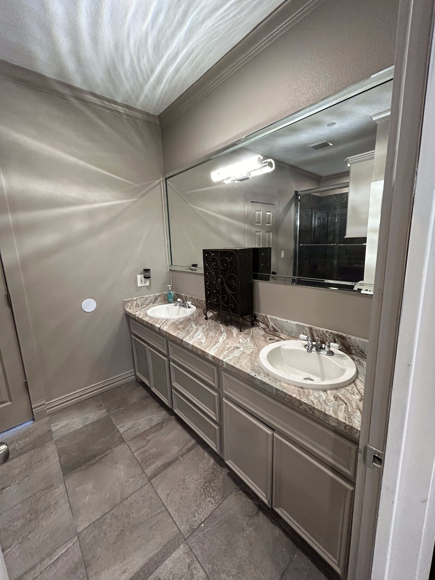 A bathroom with two sinks and a large mirror.