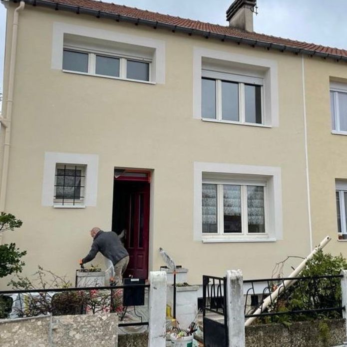 Un homme peint l'extérieur d'une maison.