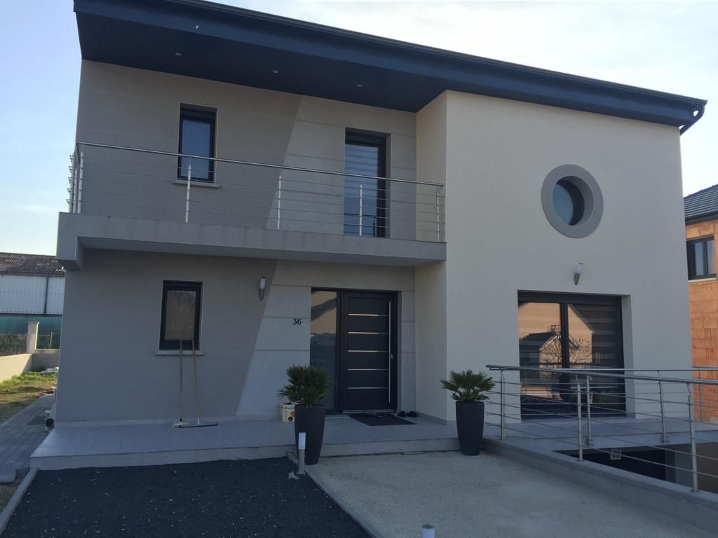 Une maison avec un balcon et une fenêtre ronde