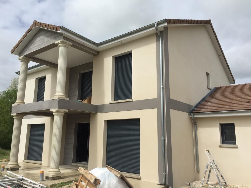 Une grande maison avec des colonnes et une échelle devant elle