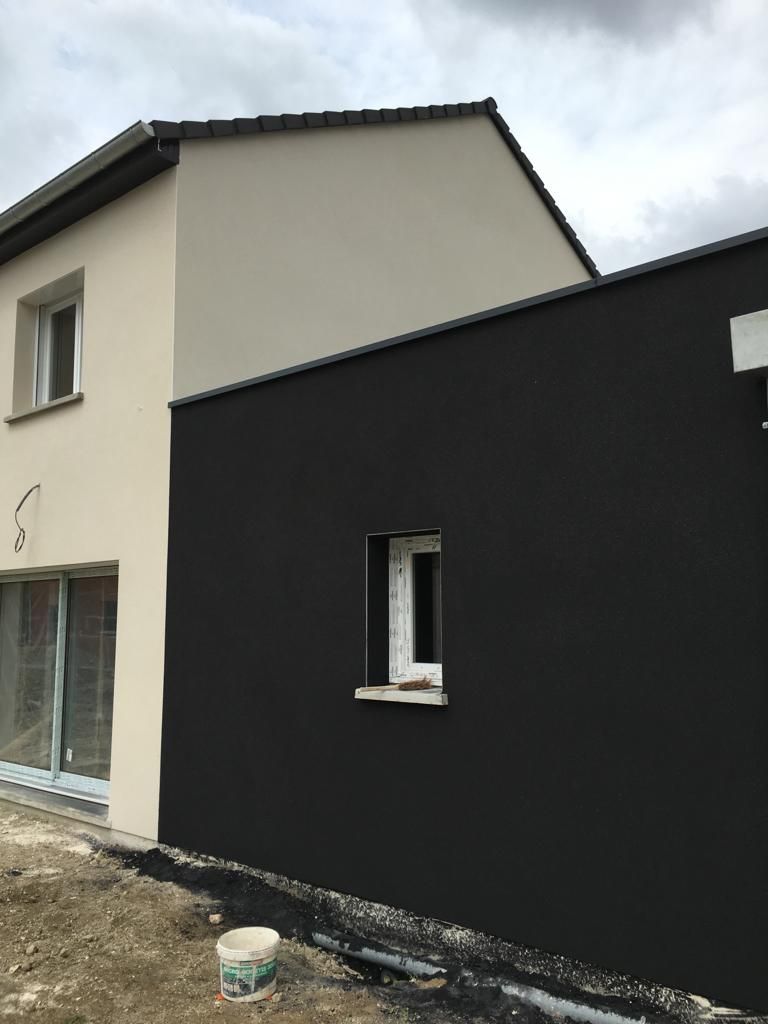 Une maison blanche avec un côté noir et une fenêtre