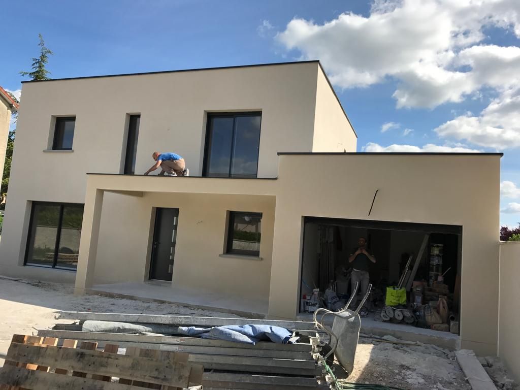 Un homme travaille sur le toit d'une maison.