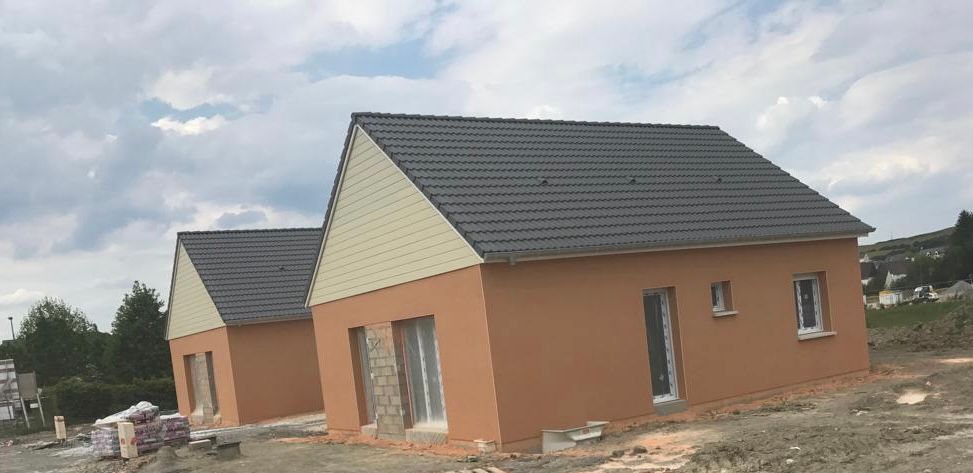 Quelques maisons sont situées l'une à côté de l'autre dans un champ.