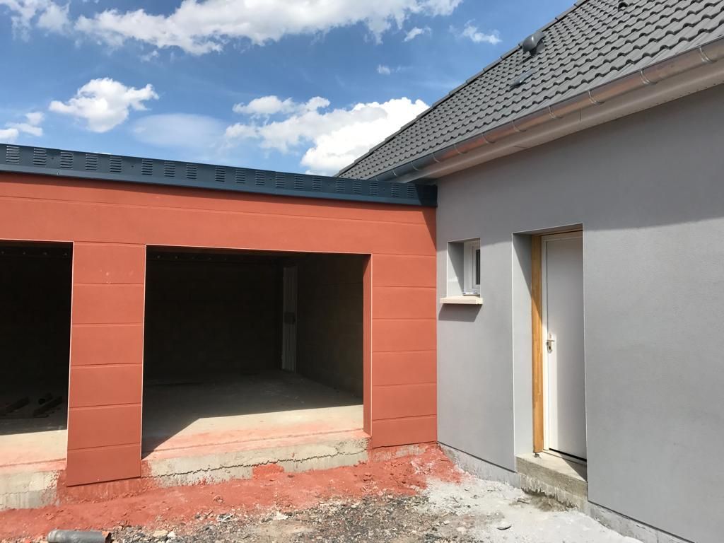 Un immeuble en construction avec un garage et une porte.