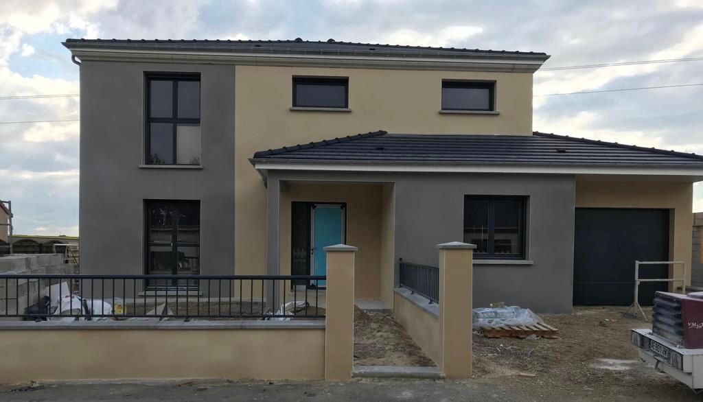 Une maison en construction avec une voiture garée devant