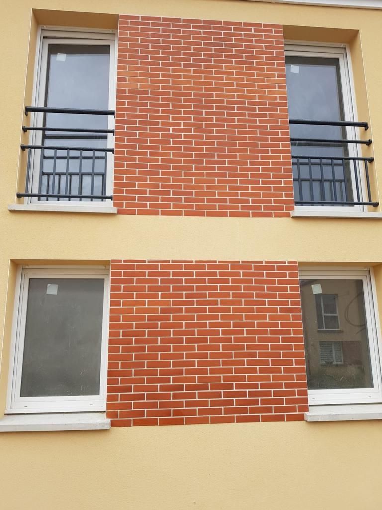 Un bâtiment en brique avec deux fenêtres et un balcon