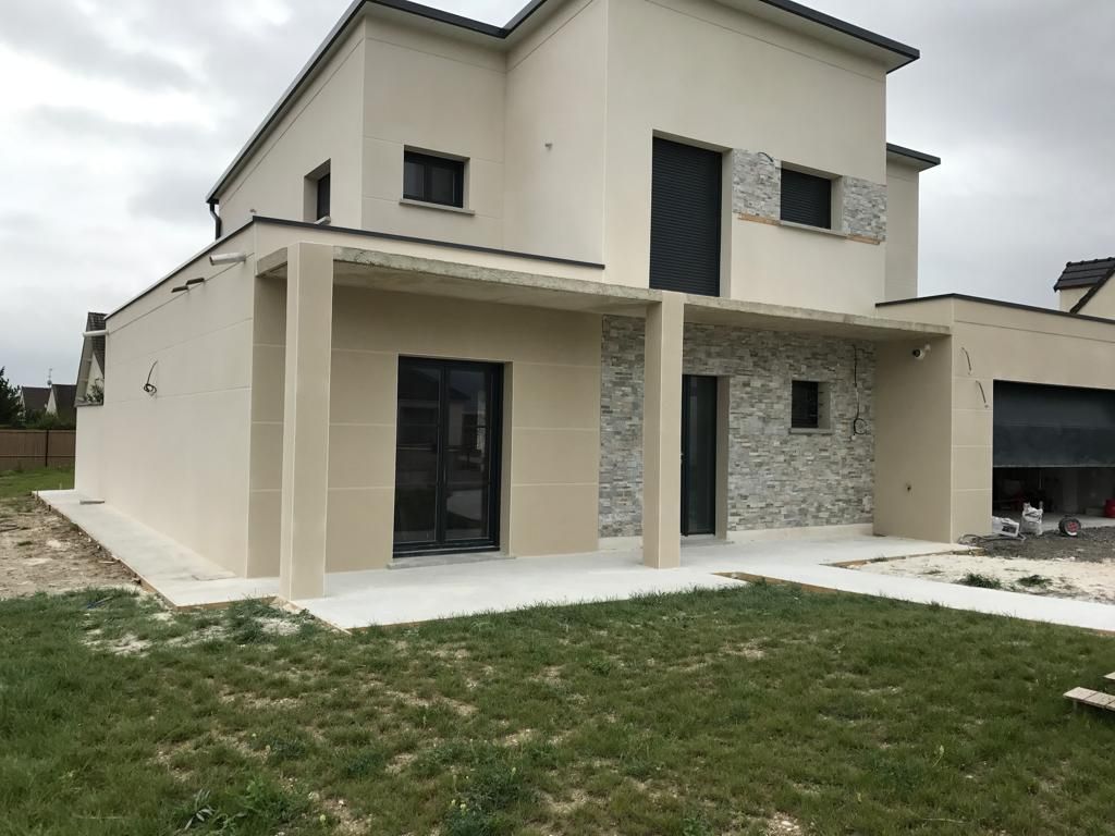 Une grande maison blanche est assise au sommet d'un champ vert luxuriant.