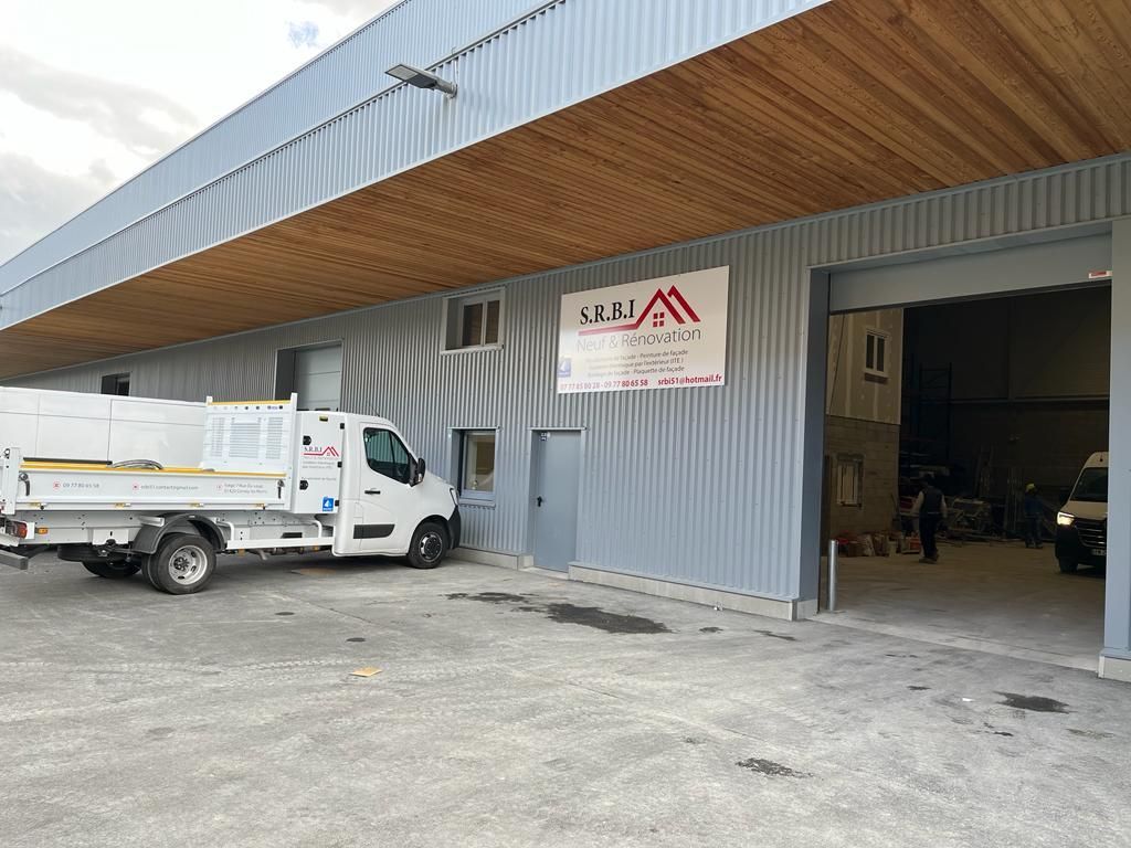 Un camion blanc est garé devant un bâtiment.