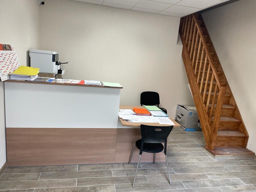 Un espace de réception avec un escalier en bois menant au deuxième étage.