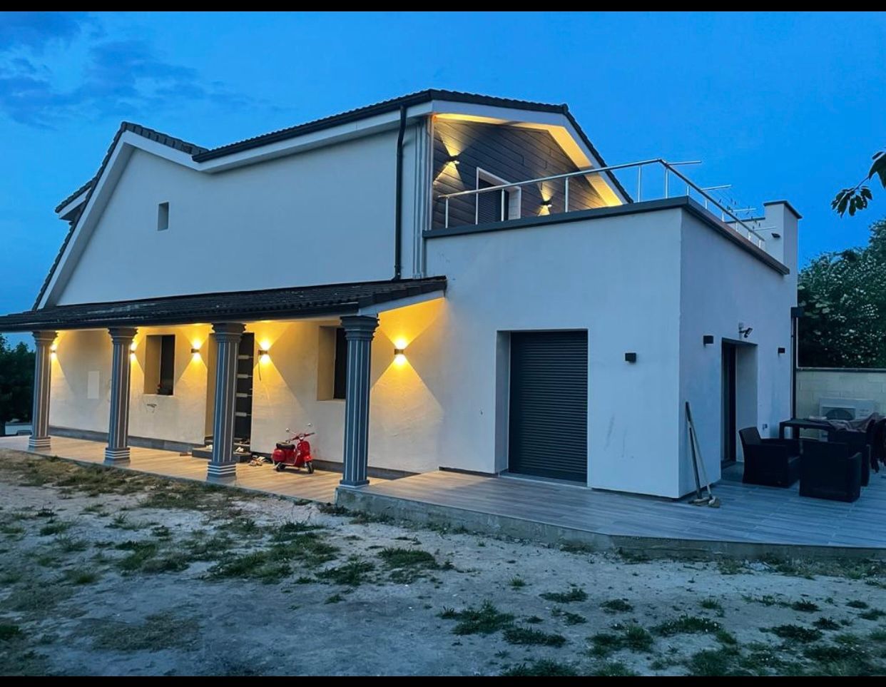 Une maison blanche avec un porche et des lumières dessus
