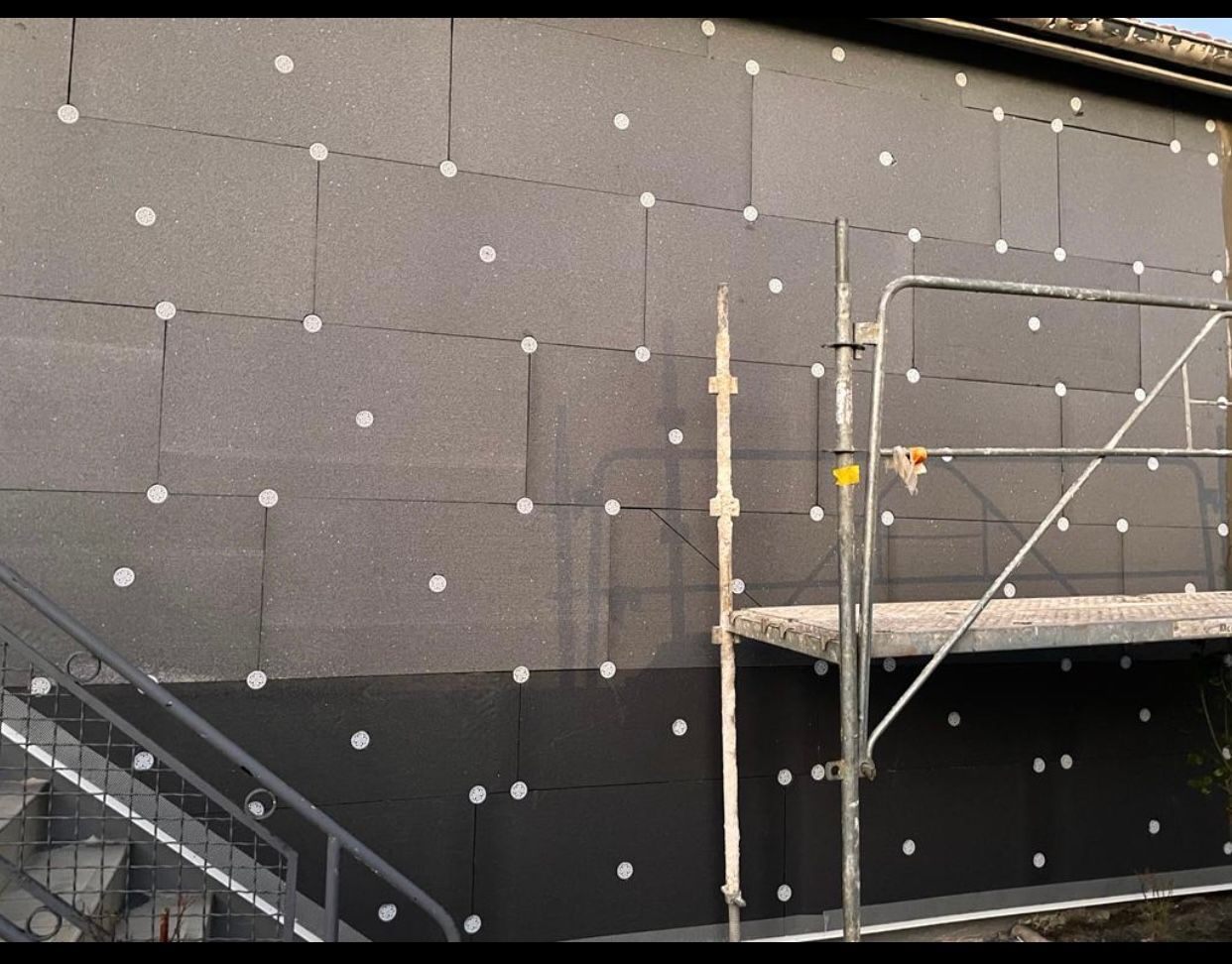 Un bâtiment avec un escalier et un échafaudage devant lui