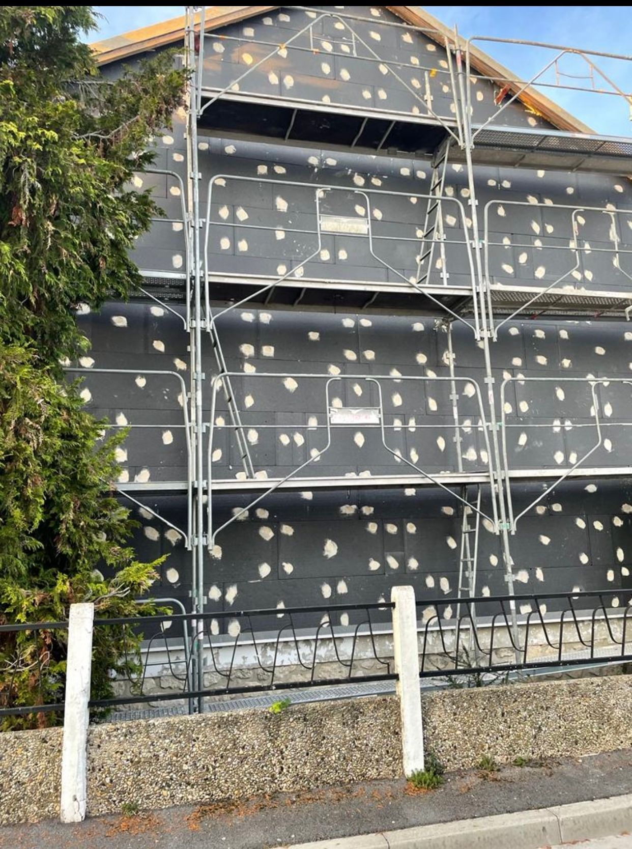 Un grand bâtiment est en cours de construction avec des échafaudages autour.