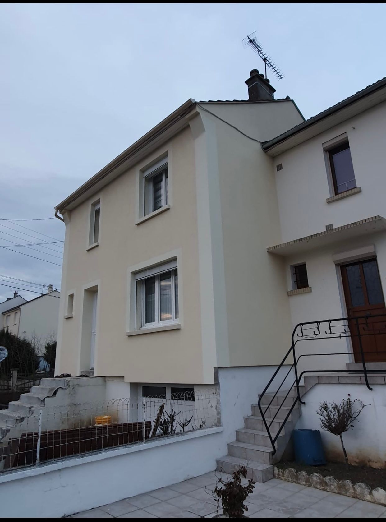 Une grande maison blanche avec des escaliers qui y mènent.