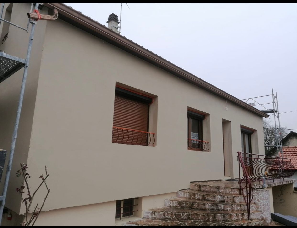 Une maison avec un balcon et des escaliers sur le côté