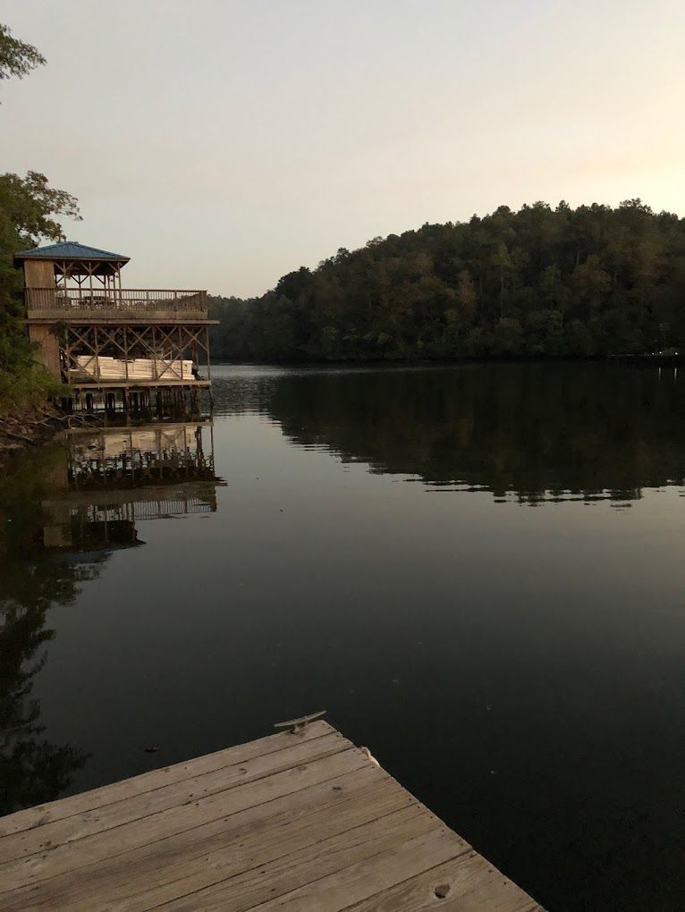 A dock overlooking a lake with a house in the background