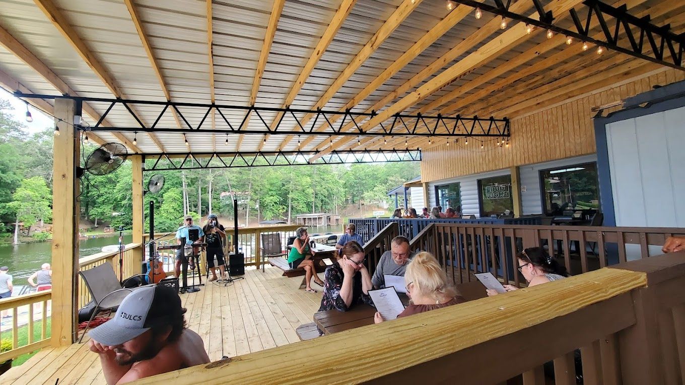 A group of people are sitting on a wooden deck.