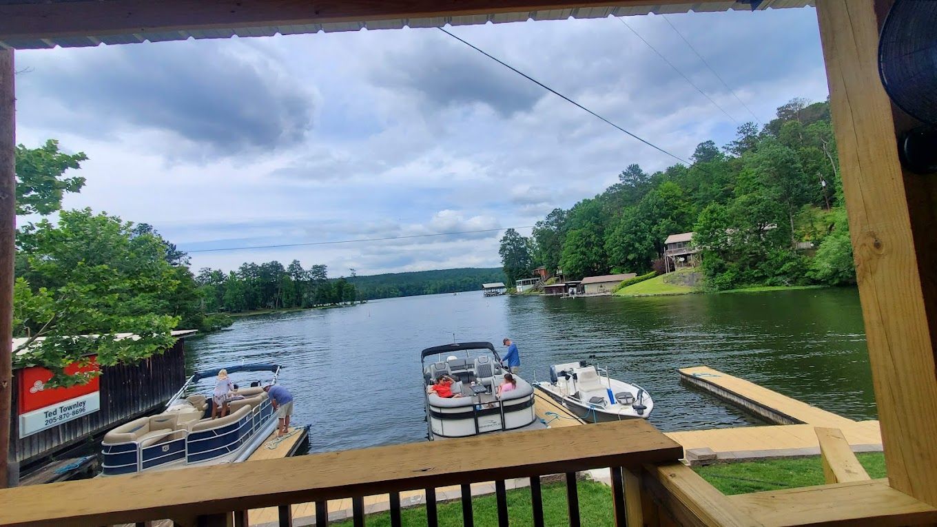 A view of a lake from a porch with boats docked.