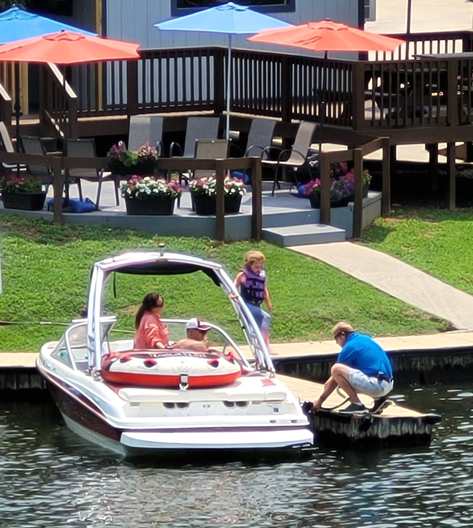 A man sitting on a dock next to a boat