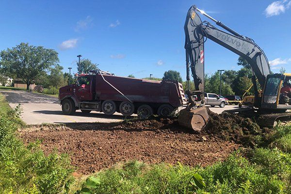 Excavator and Red Truck — Eden, WI — Baumhardt Sand & Gravel, Inc.