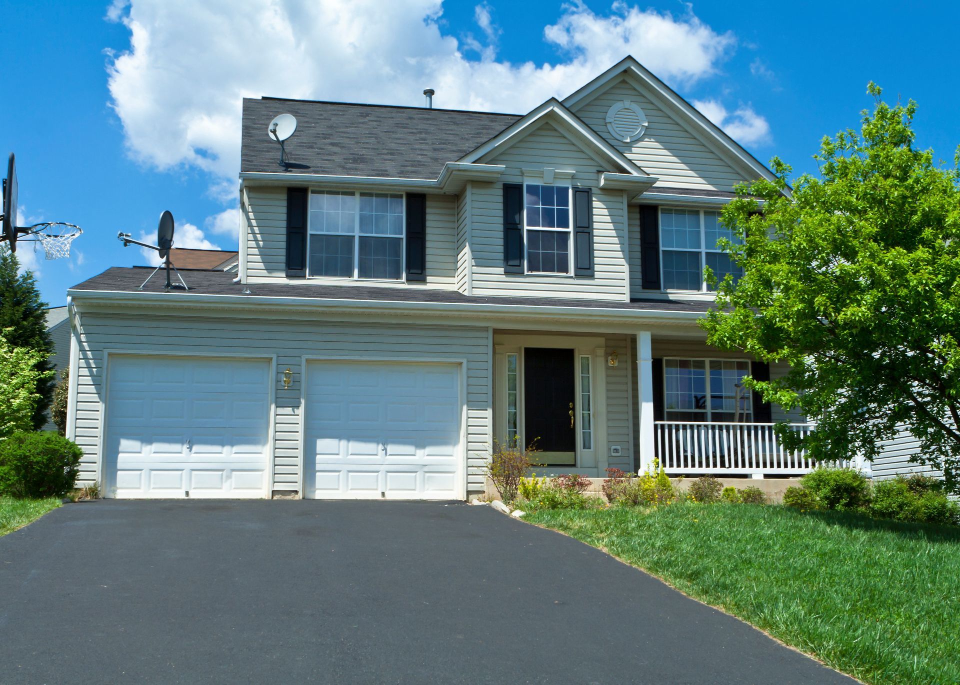 A charming suburban family home with an asphalt driveway leading up to the house.