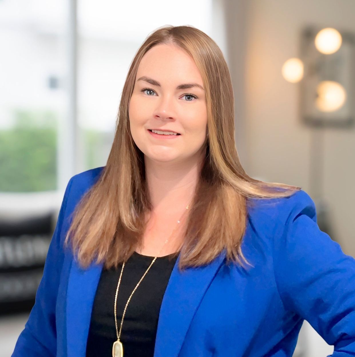 A headshot of Realtor Paige Summers wearing a blue jacket and a black shirt