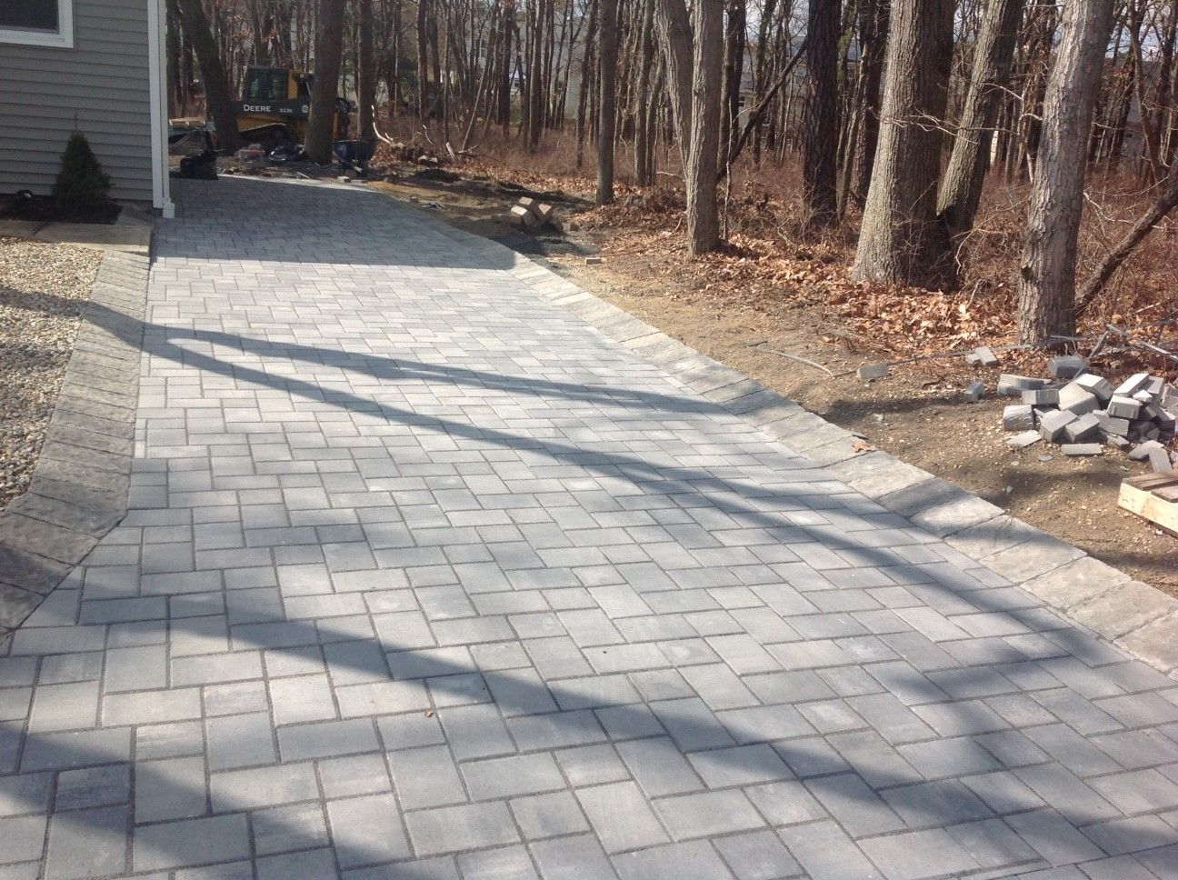 A brick walkway leading to a house in the woods