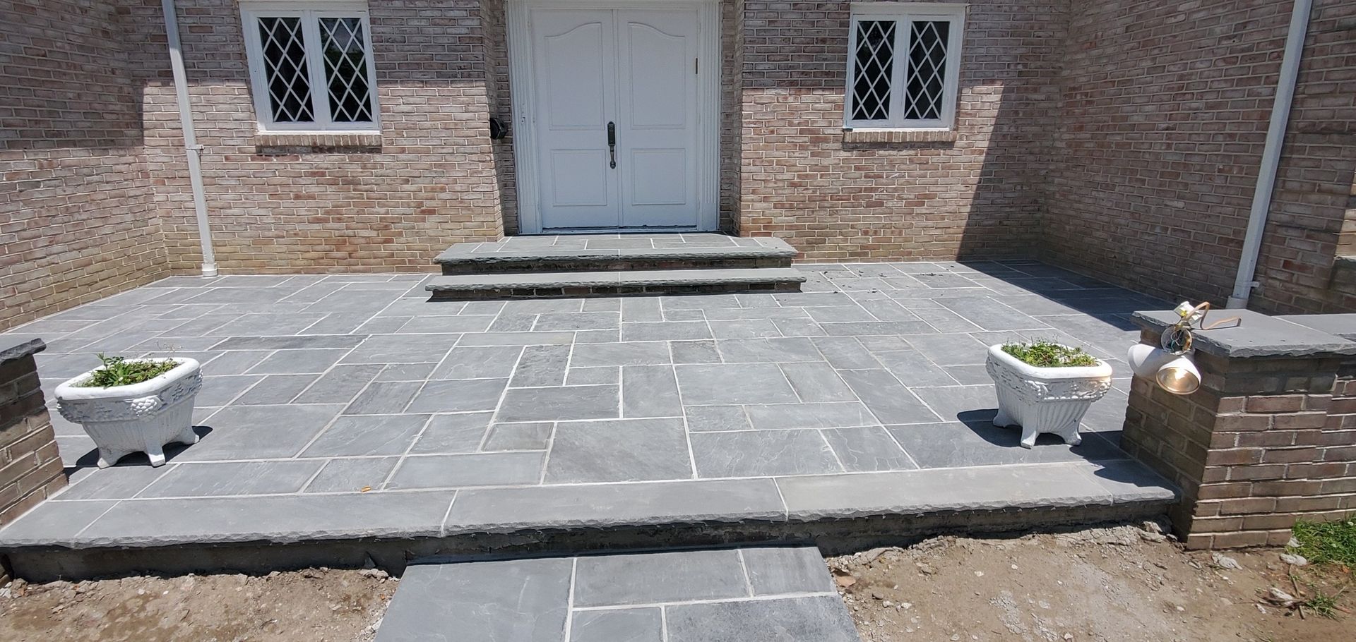 A stone walkway leading to the front door of a brick house