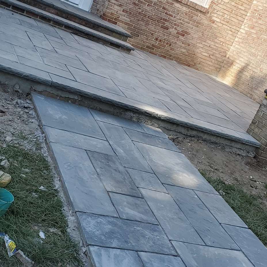 A sidewalk is being built in front of a brick building.