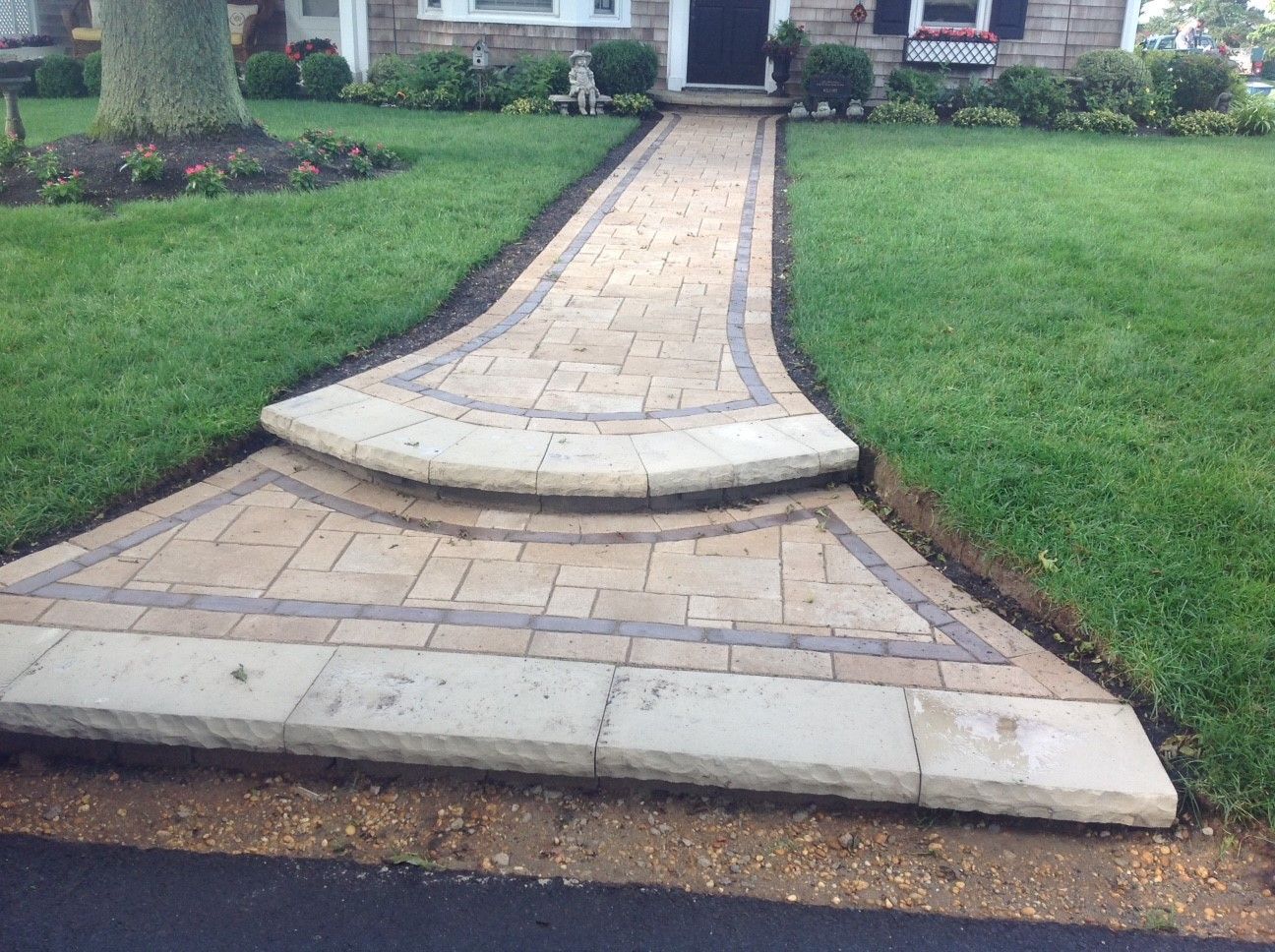 A brick walkway leading to the front door of a house.