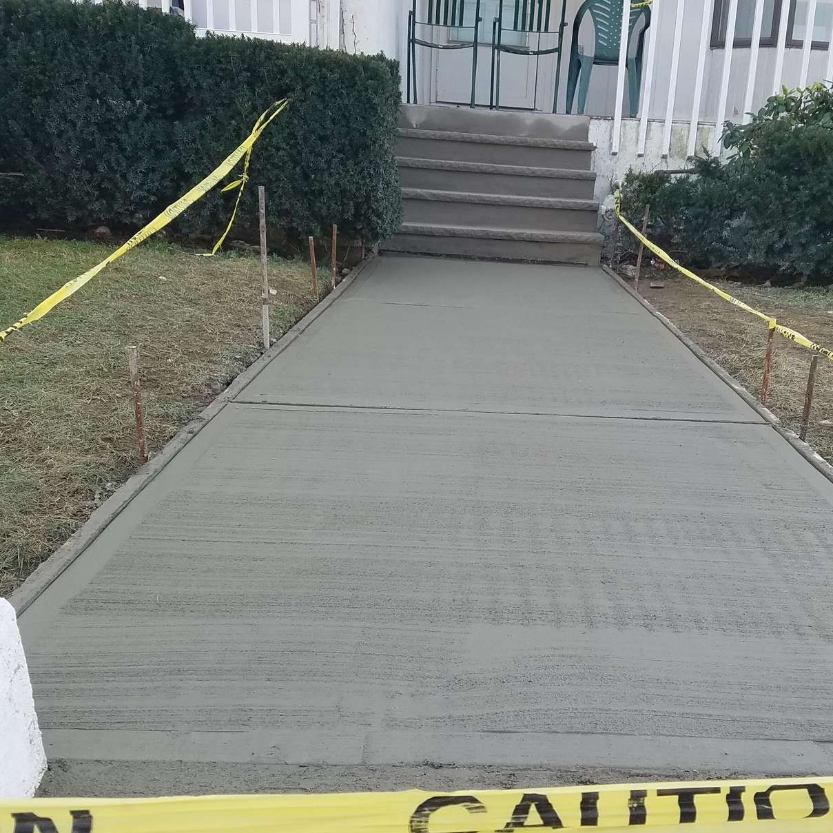 A concrete walkway with a yellow caution tape around it